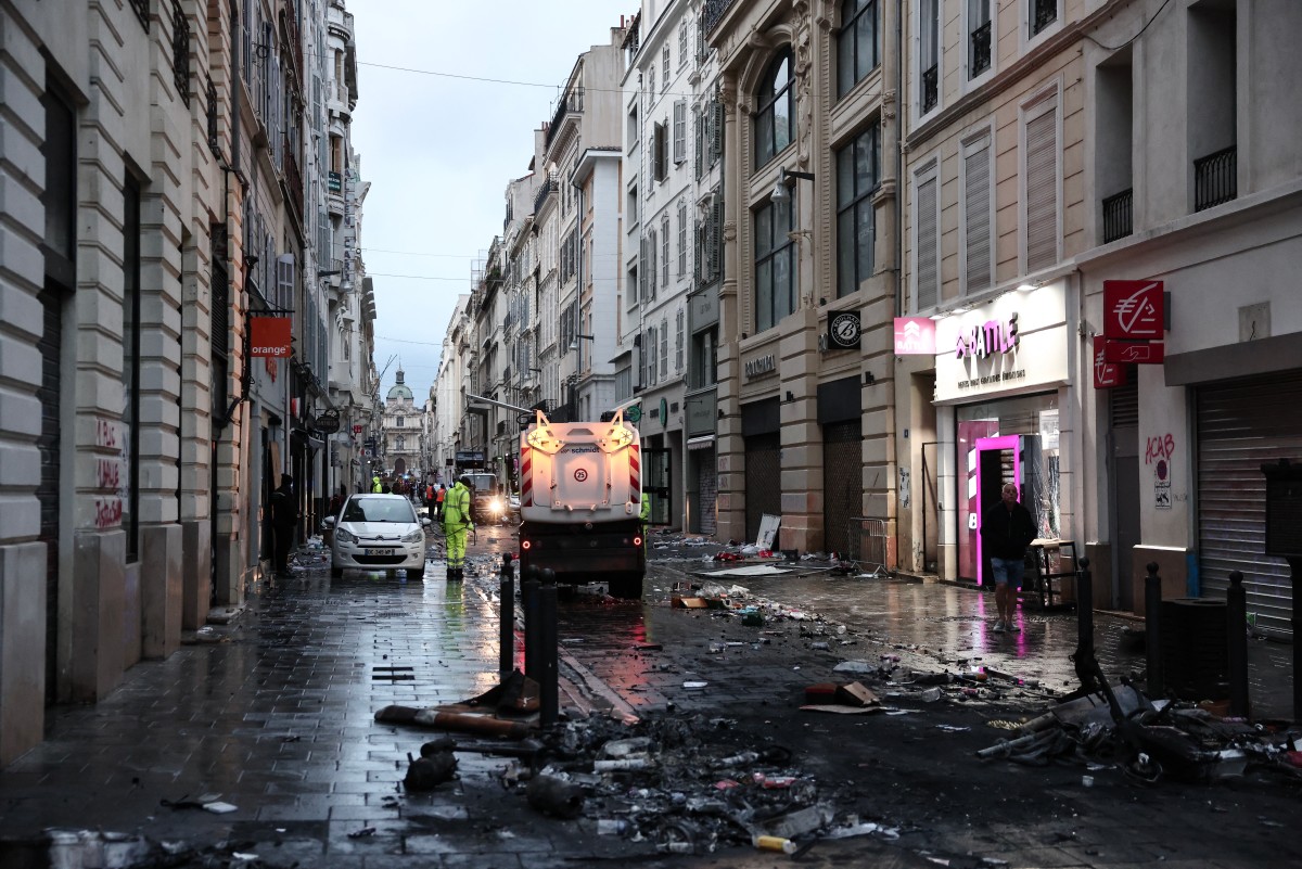 Municipal cleaning workers clean a street a day after nationwide protests against the "high cost of living", in Marseille on October 18, 2026. (Photo by Thibaud MORITZ / AFP)